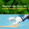 Lumineux® toothpaste tube dispensing foamy mint paste onto toothbrush bristles