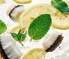 Sliced lemons and fish on a white background with water droplets